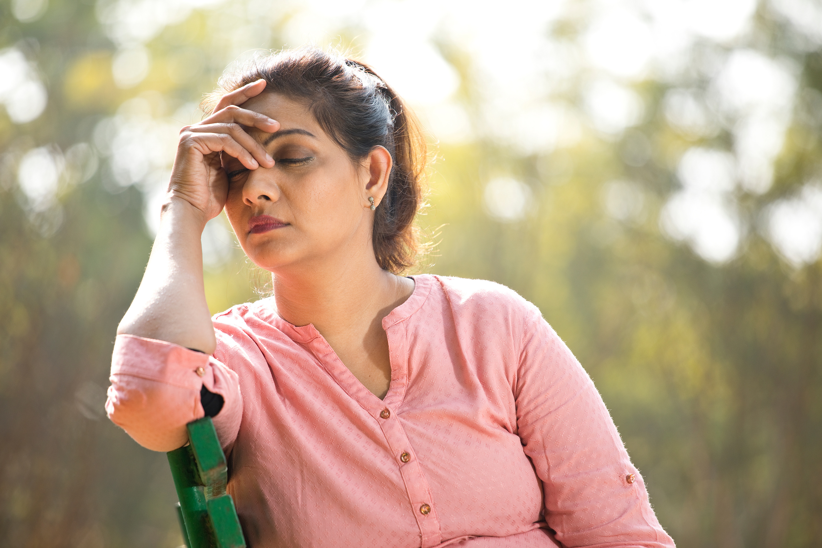 Worried woman with head in hands